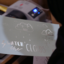 A white paper with silver foiled drawings of clouds.