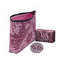 A travel beauty set including a pink zip pouch, pocket mirror and soap bar featuring a matching pattern.